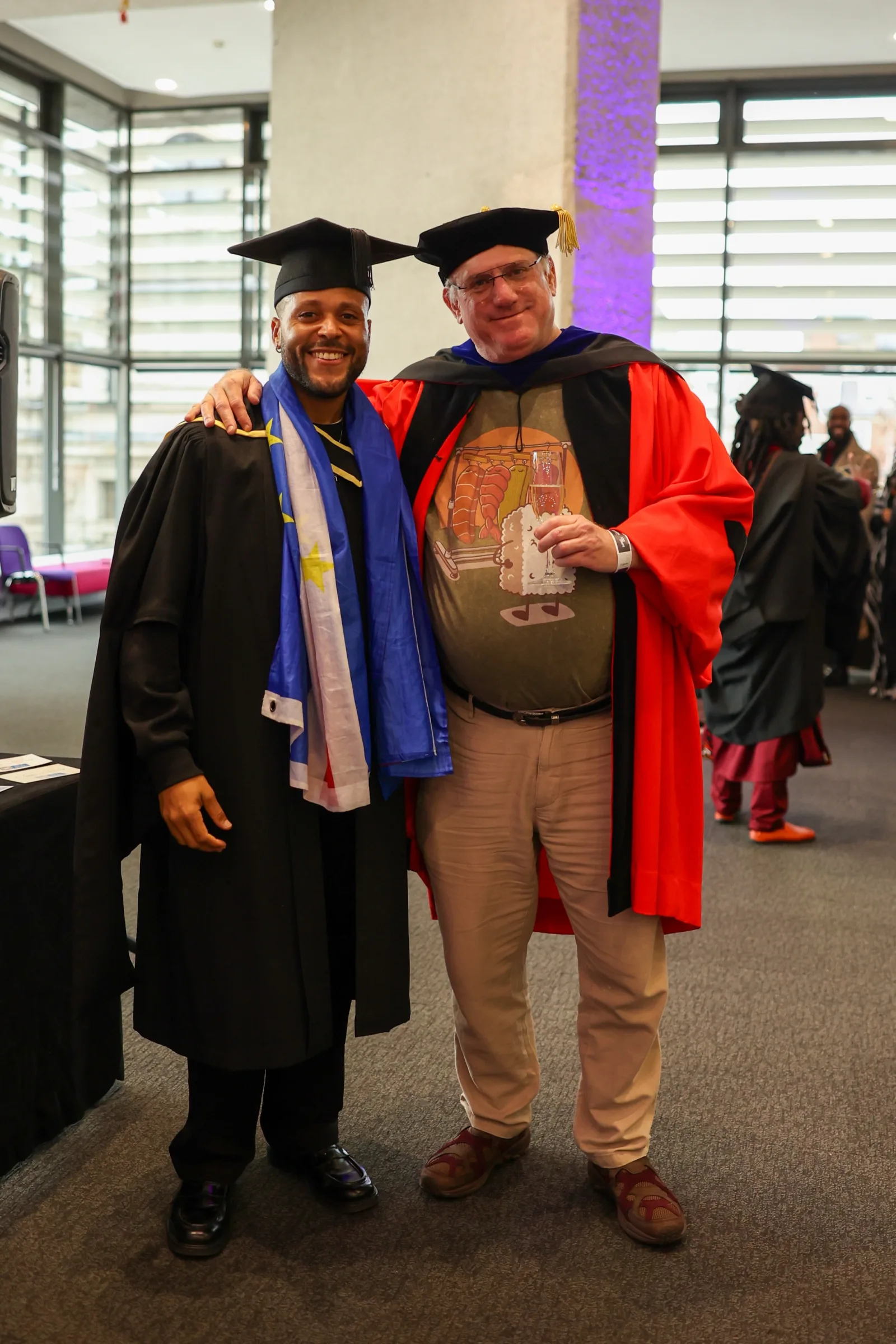 Joelson at graduation with Professor Yoram Chisik, program director at the University of London, with the Cabo Verdean flag over his shoulders
