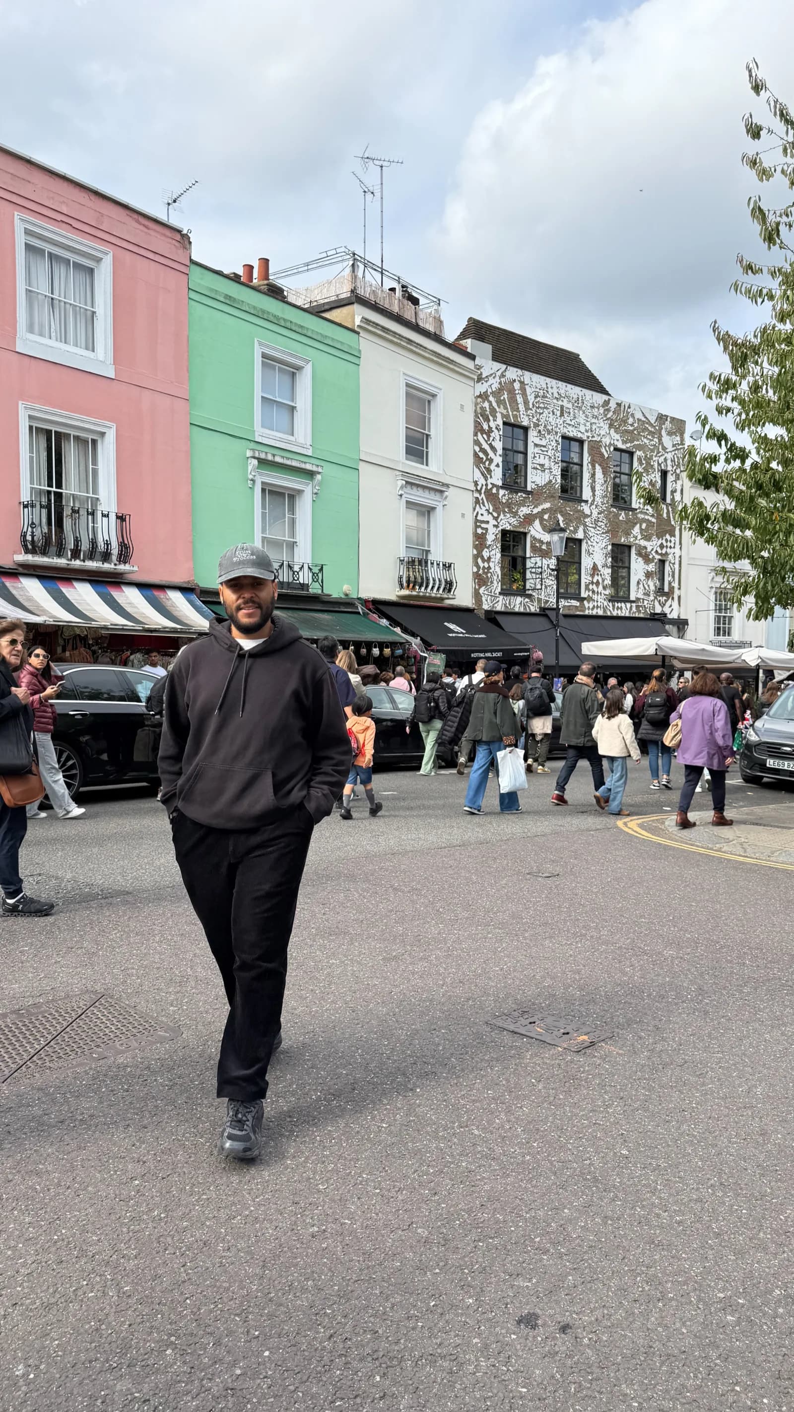 Joelson strolling the streets of Notting Hill in London, colourful houses behind him